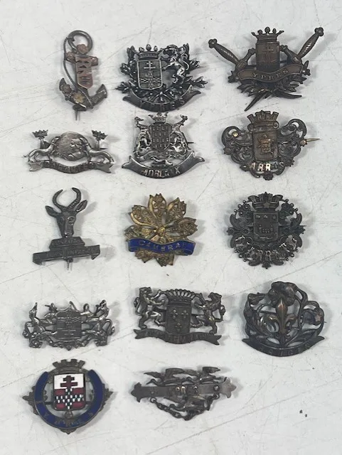 A collection of mainly WWI military sweetheart brooches naming Ypres, Cambrai, Biarritz, Bruges, Morlaix, etc