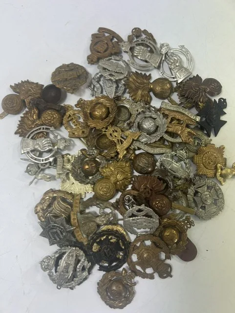 A large collection of early 20th century cap badges, collar badges and shoulder titles to include The Devonshire Reg, (HAC) Honorable Artillery Company