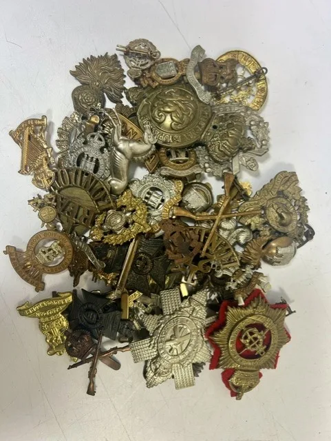 A large collection of early 20th century cap badges, collar badges and shoulder titles to include the Black Watch, King's Royal Regiment