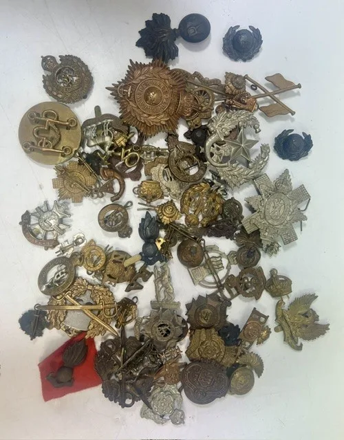 A large collection of early 20th century cap badges, collar badges and shoulder titles to include South Lancashire Prince of Wales Volunteers