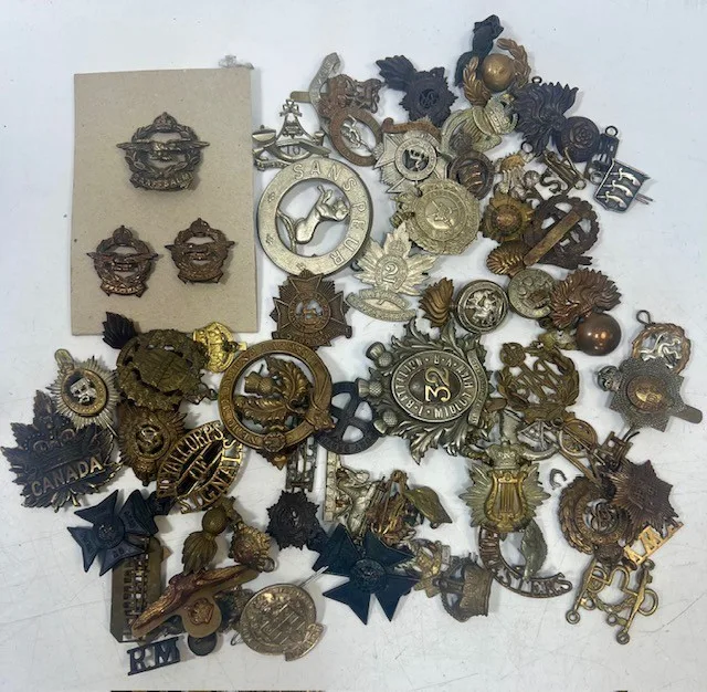 A large collection of early 20th century cap badges, collar badges and shoulder titles to include 10th Battalion London Regiment, Ley's Officer training Corps