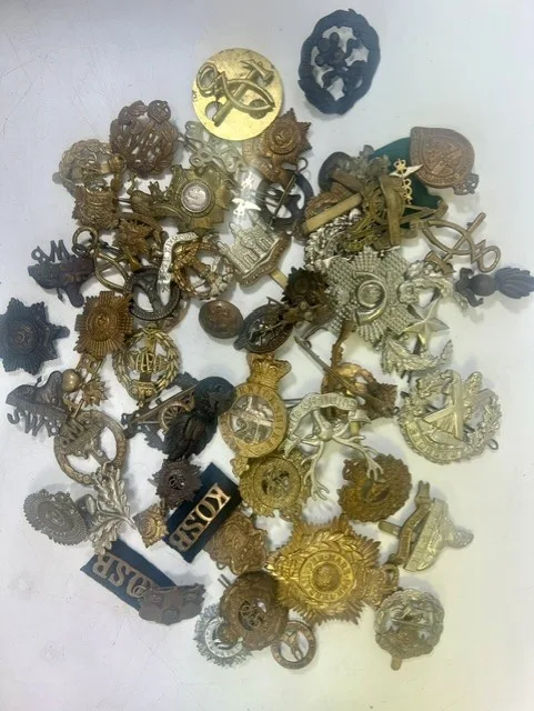 A large collection of early 20th century cap badges, collar badges and shoulder titles to include South Lancashire Prince of Wales Volunteers