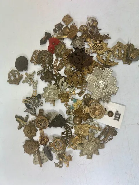 A large collection of early 20th century cap badges, collar badges and shoulder titles to include Canada, General Service, Royal Artillery, West Riding