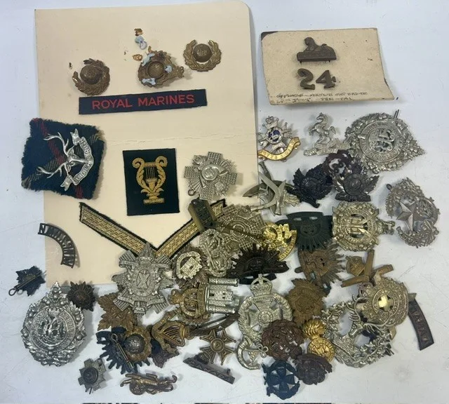 A large collection of early 20th century cap badges, collar badges and shoulder titles to include Australian Commonwealth, Machine Gun Corps