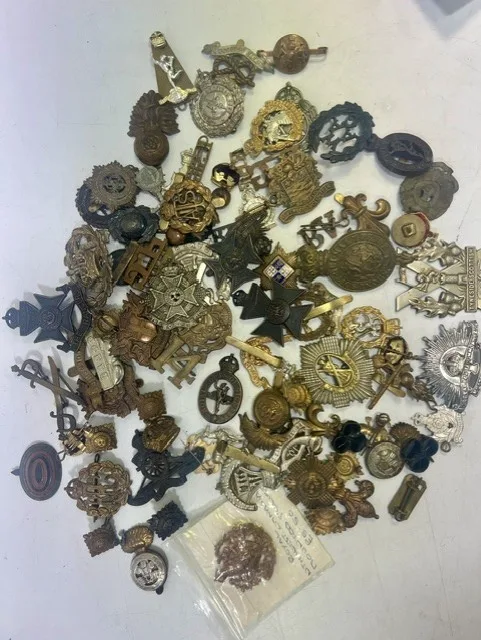 A large collection of early 20th century cap badges, collar badges and shoulder titles to include Blackpool Volunteers, Dental Corps, WWI Glengarry hat badge