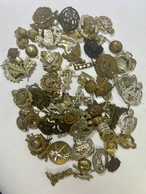 A large collection of early 20th century cap badges, collar badges and shoulder titles to include University of London Training Corps
