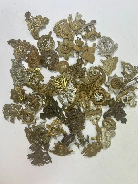 A large collection of early 20th century cap badges, collar badges and shoulder titles to include Norfolk, Cambridgeshire, North Staffordshire, Worcestershire